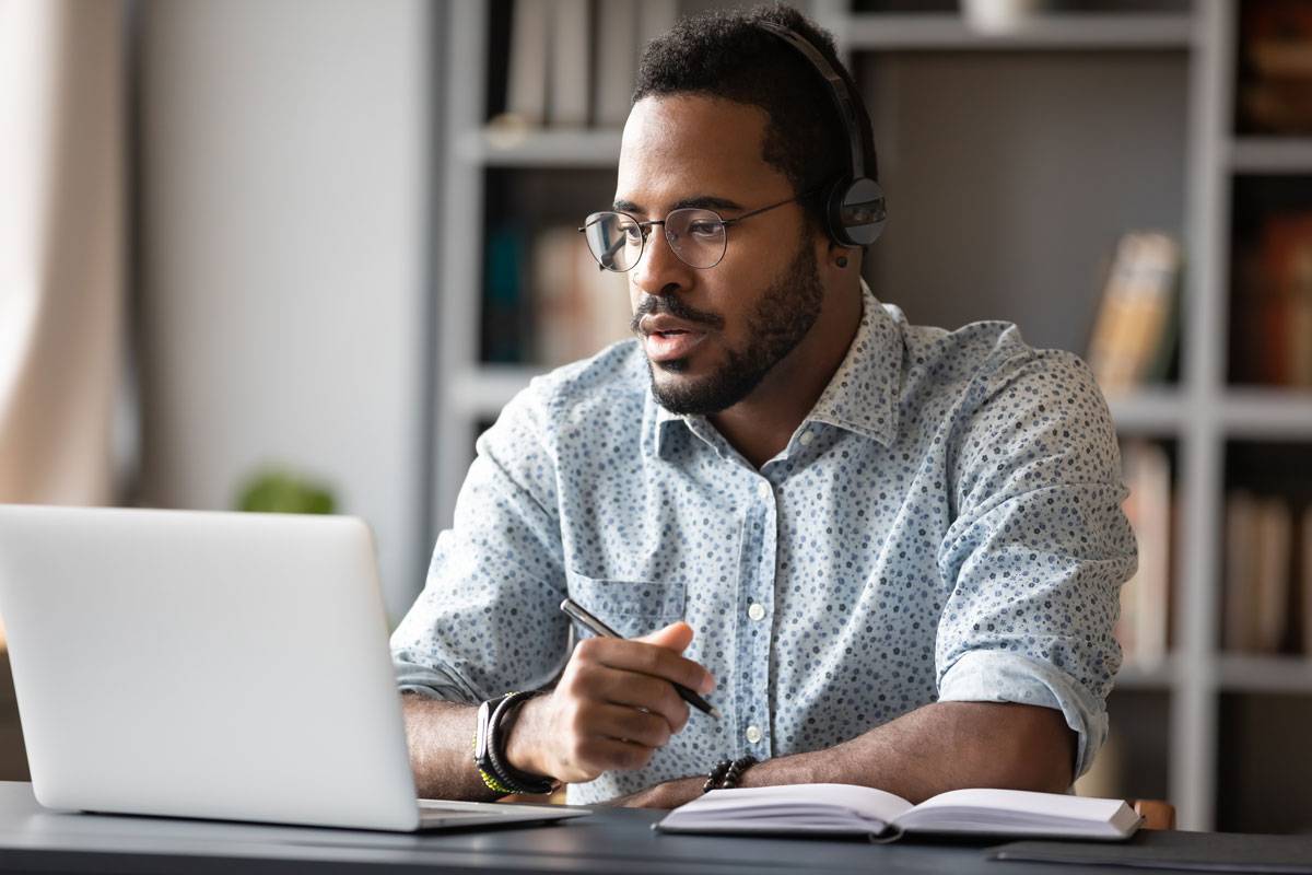 man sitting at desk with laptop