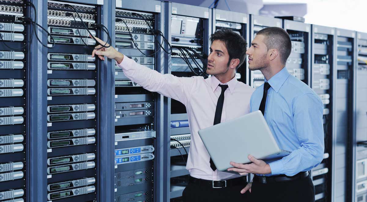 IT engineers in network server room solving problems and give co-managed IT help and support.