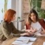 Two female entrepreneurs working together using laptop looking at computer