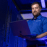 Hamilton tech working in the Hamilton data center holding laptop