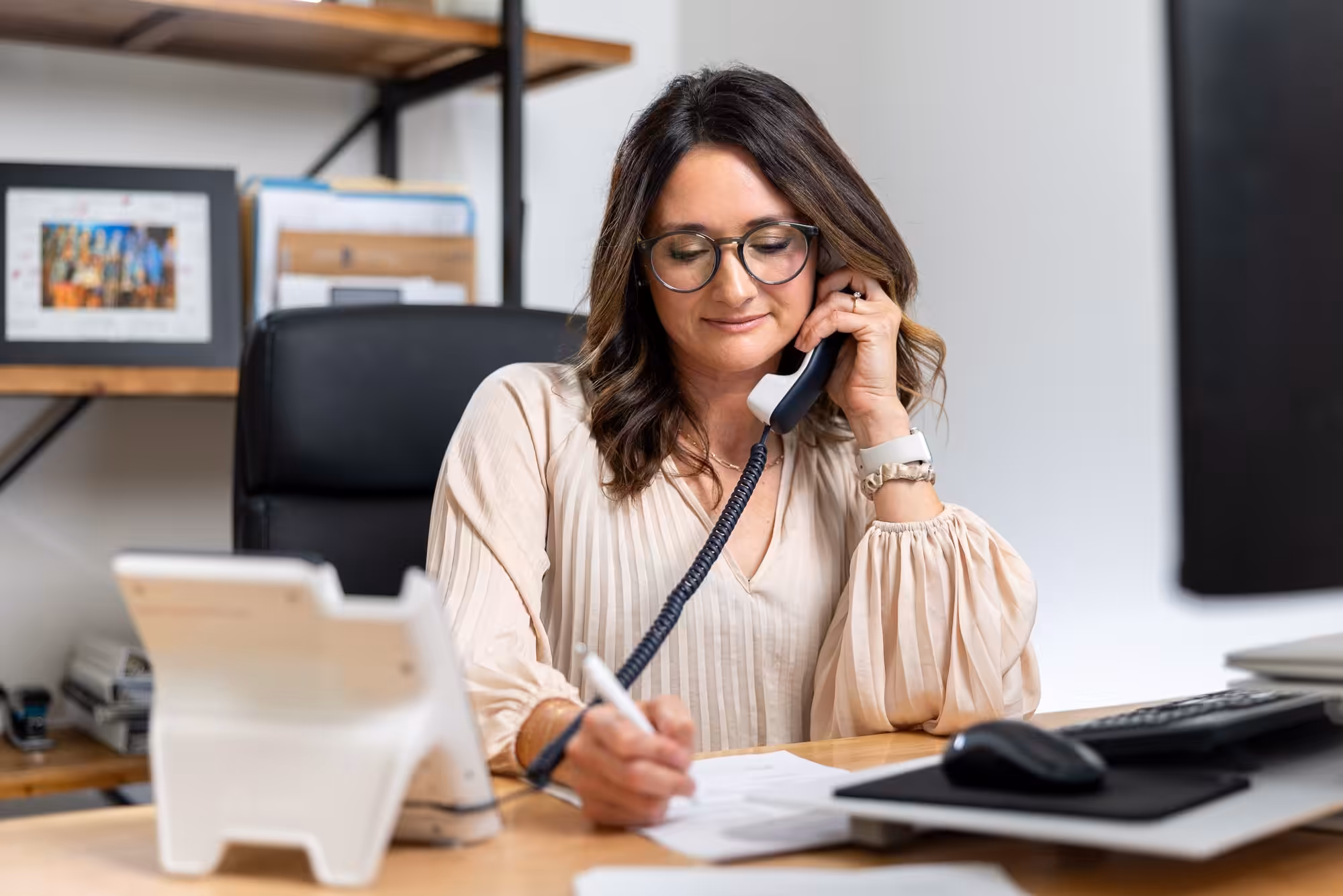 Lady on the phone while taking notes