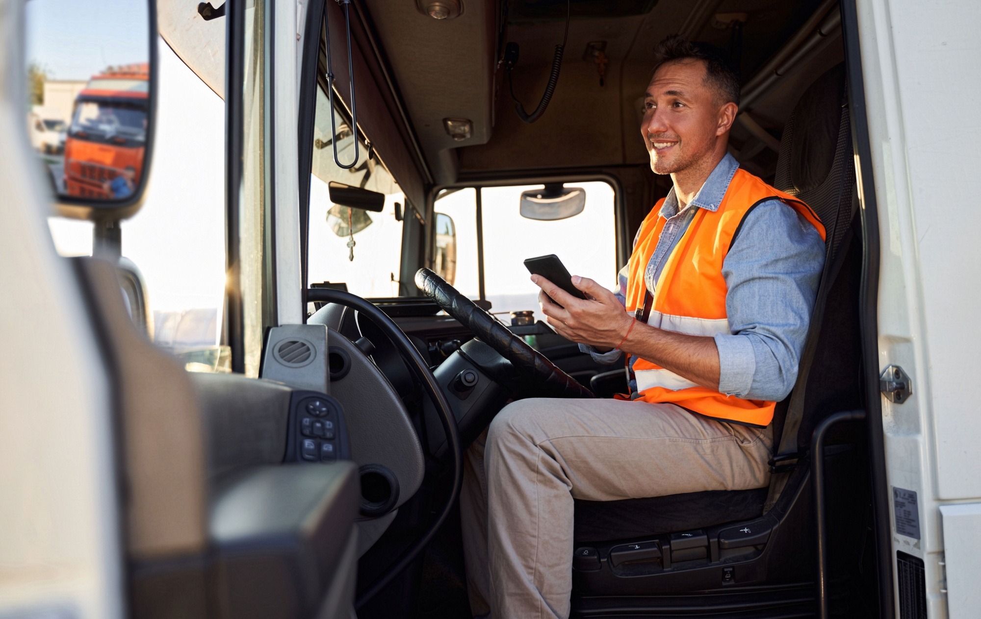 Driver takes order updates from the office on his mobile phone which is why business phone systems matter more than ever in today’s digital age. Driver takes order updates from the office on his mobile phone which is why business phone systems matter more than ever in today's digital age.