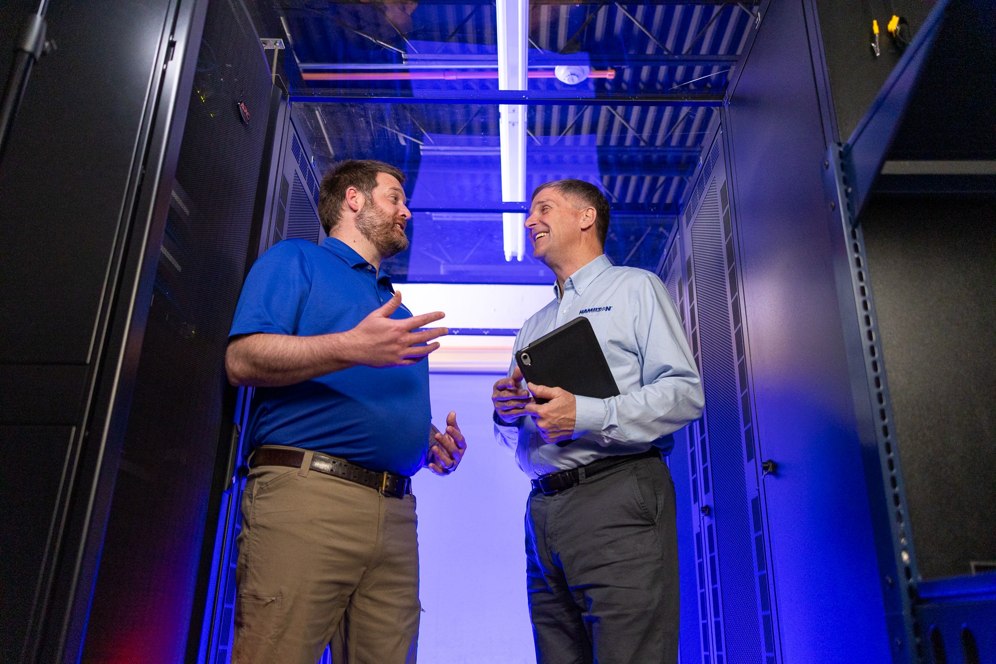 2 hamilton techs standing in the Hamilton Data center managing the network