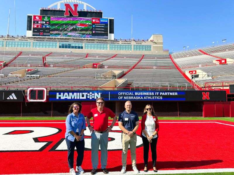 Hamilton employees, standing in memorial stadium in lincoln nebraska.