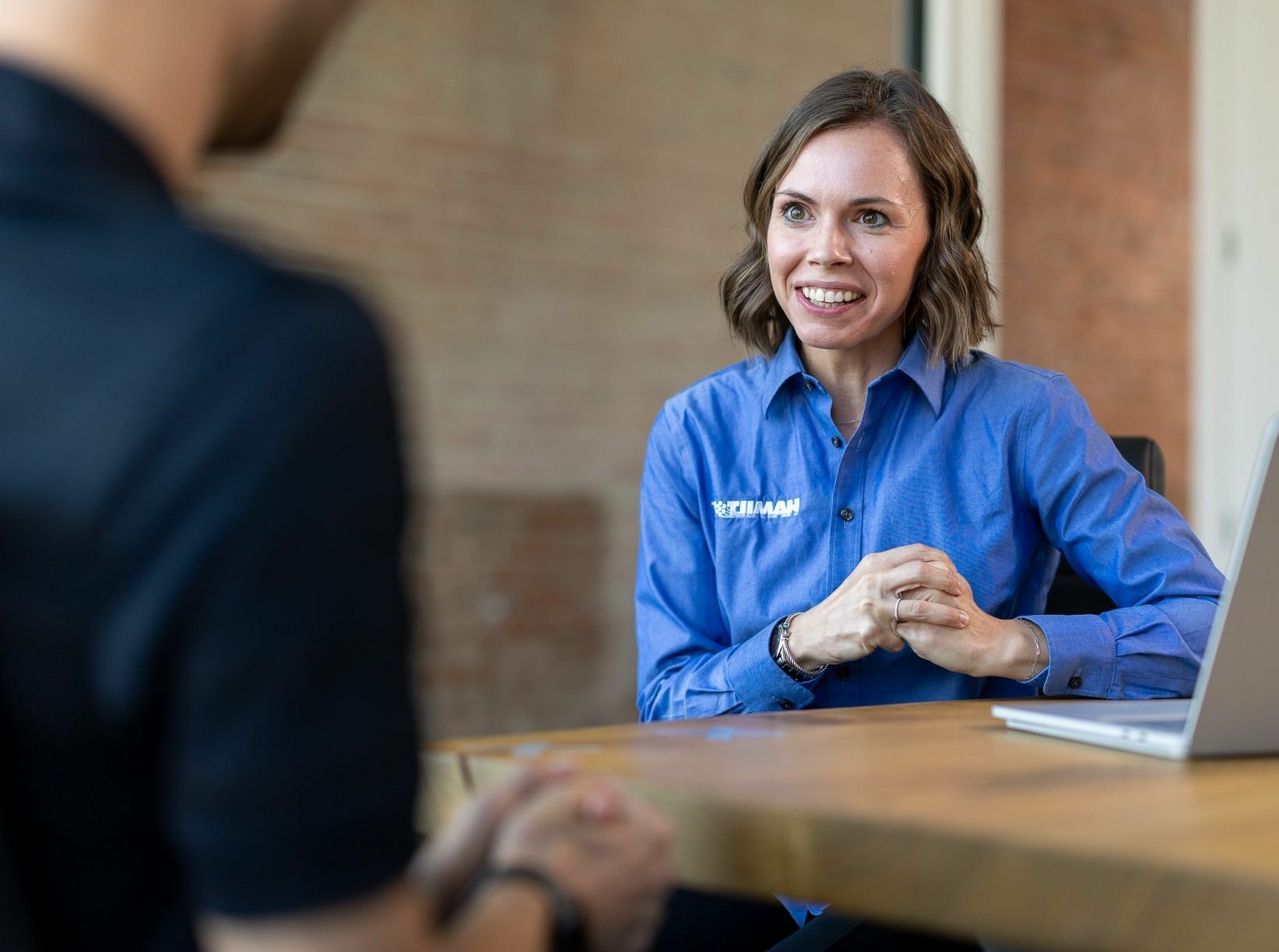 Hamilton Business Technologies Sales Woman sitting at a table talking with a MSP client