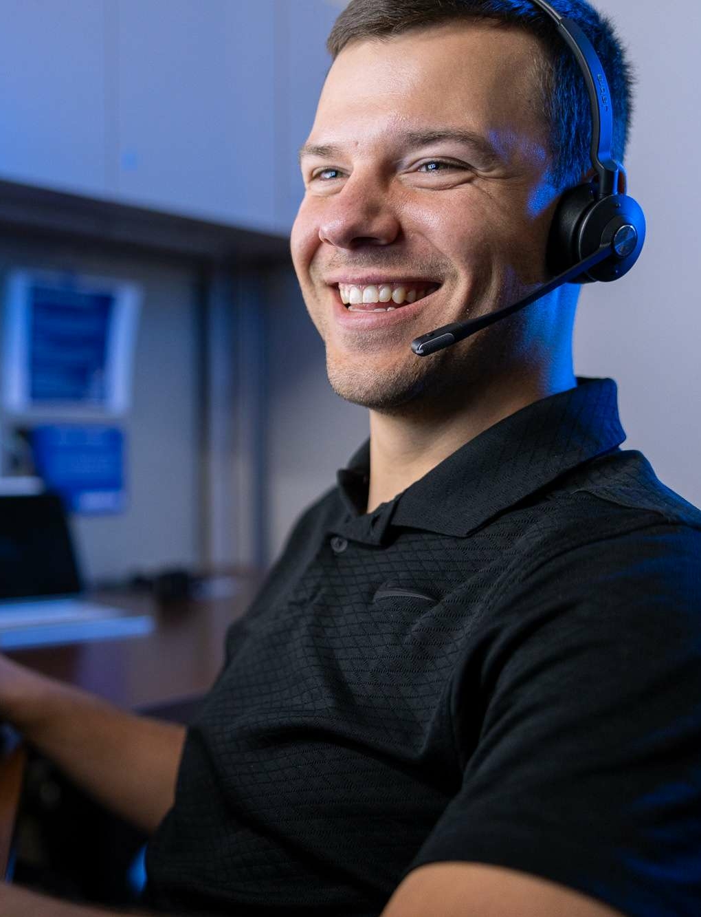 Hamilton tech smiling while on a hamilton business phone with a customer