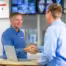 Hamilton Salesman shaking hands with a school principle with hamilton security system in the background